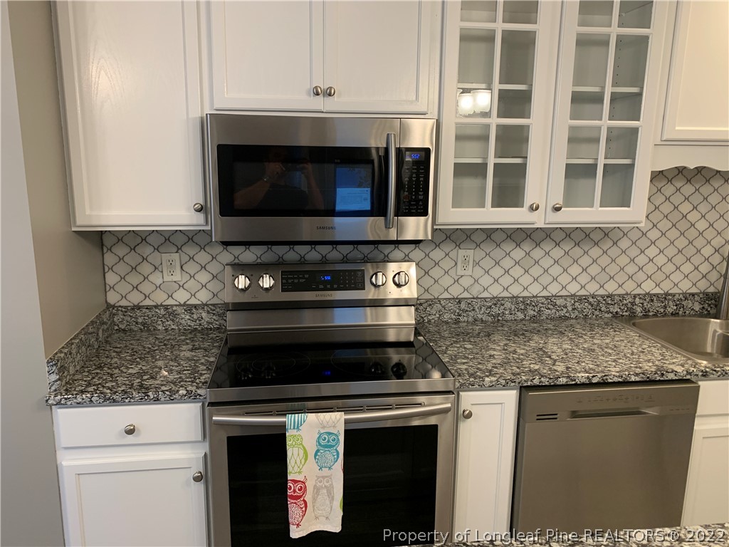 5428 Arnette Road Hope Mills, NC 28348 - Photo 26 of 41 a kitchen with granite countertop a stove top oven cabinetry and granite counter tops