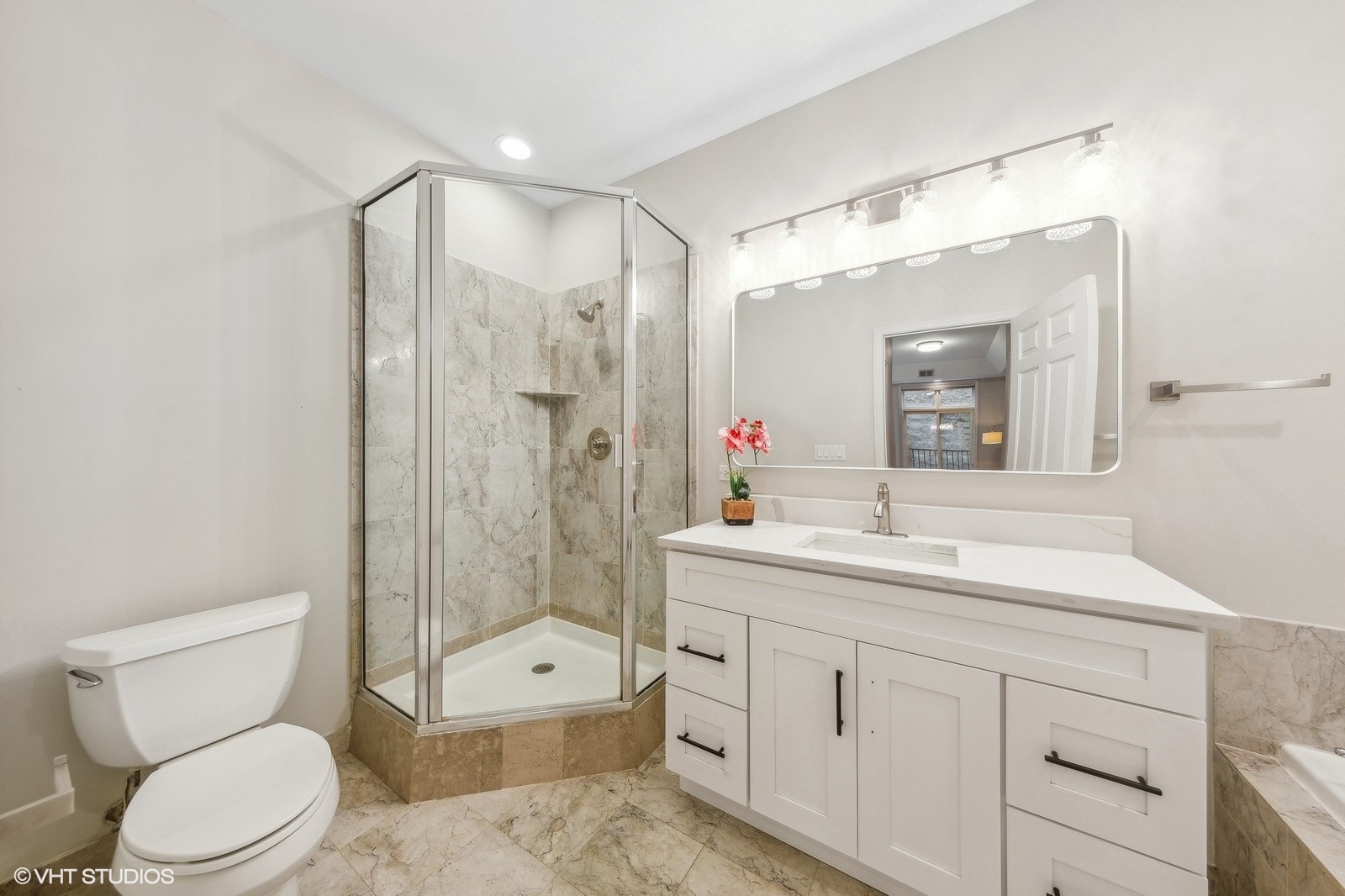 820 West Hubbard Street, Unit 4 Chicago, IL 60642 - Photo 17 of 28 a bathroom with a toilet a sink a glass door a shower a mirror and vanity