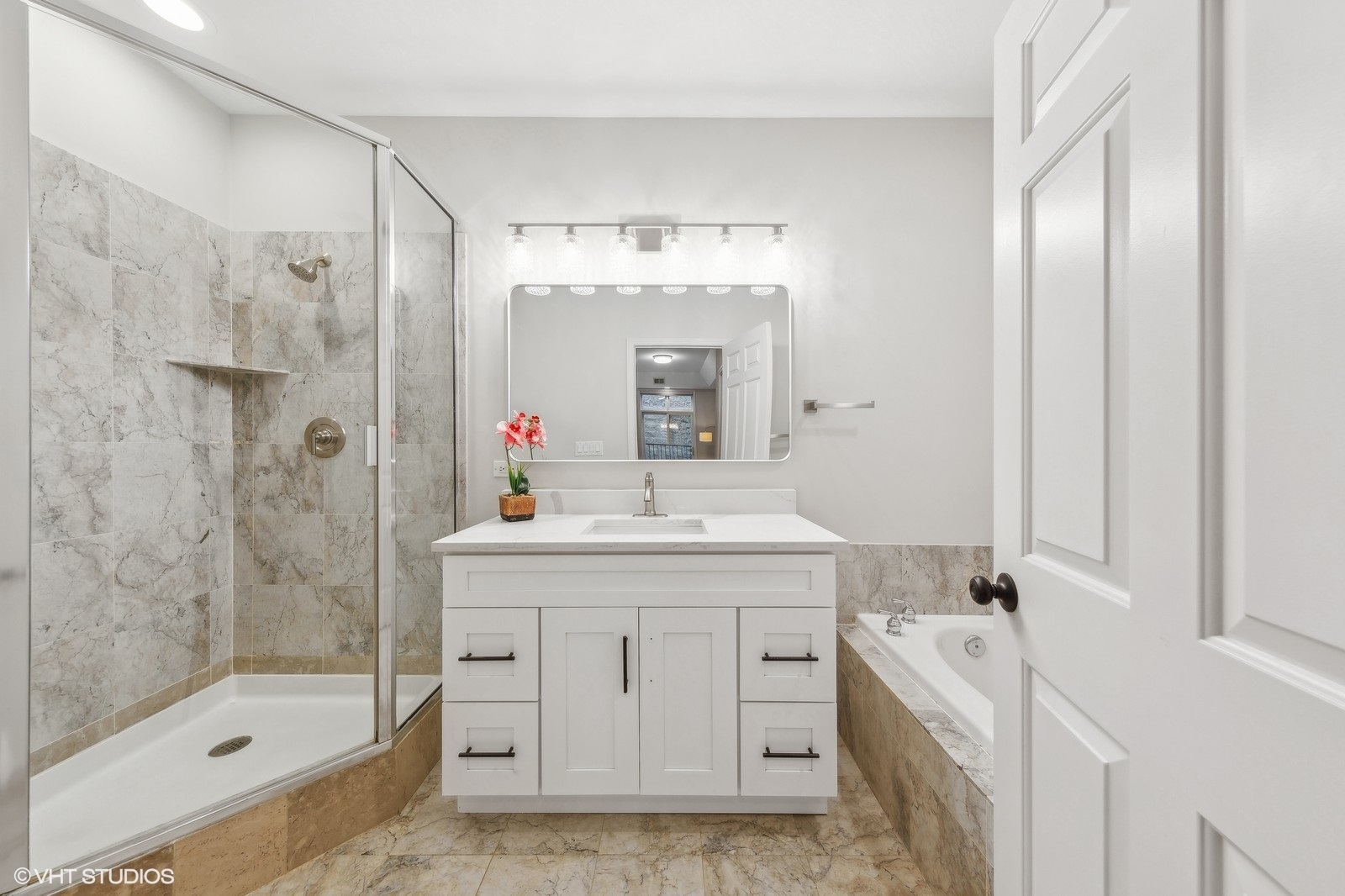 820 West Hubbard Street, Unit 4 Chicago, IL 60642 - Photo 18 of 28 a bathroom with a granite countertop sink a mirror a shower and a bathtub