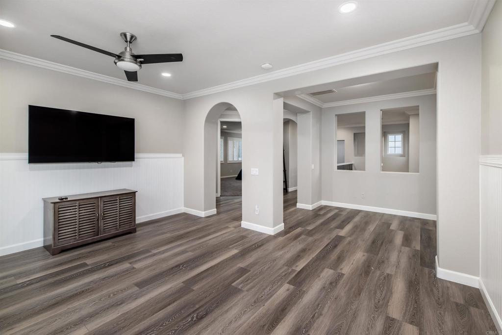 1459 Lighthouse Road San Marcos, CA 92078 - Photo 26 of 50 a view of a livingroom with a flat screen tv wooden floor and a ceiling fan