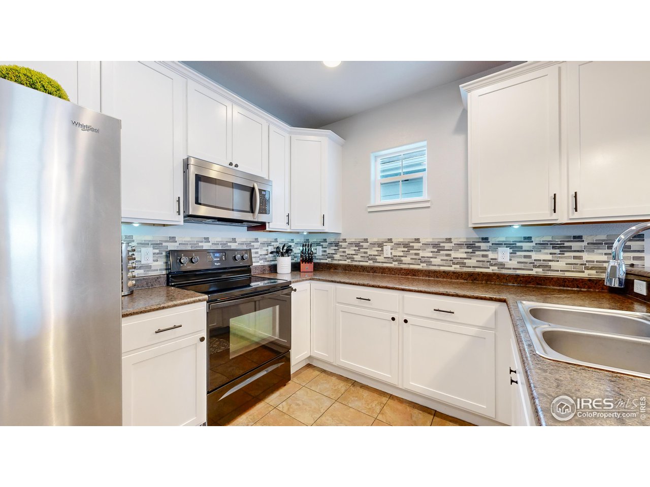 511 Wind River Drive Windsor, CO 80550 - Photo 6 of 22 a kitchen with granite countertop white cabinets and stainless steel appliances