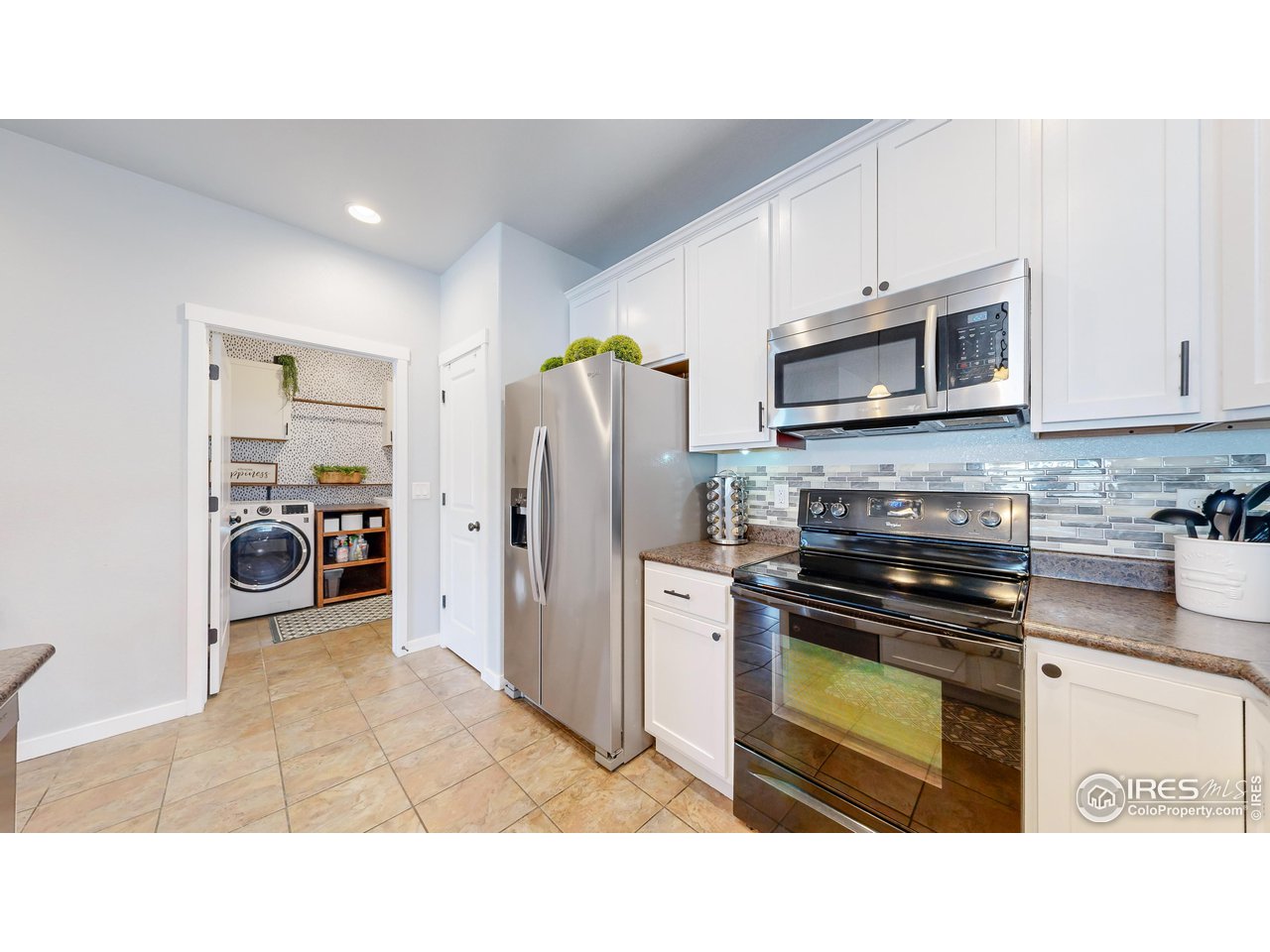 511 Wind River Drive Windsor, CO 80550 - Photo 7 of 22 a kitchen with stainless steel appliances a refrigerator a stove a sink cabinets and a window