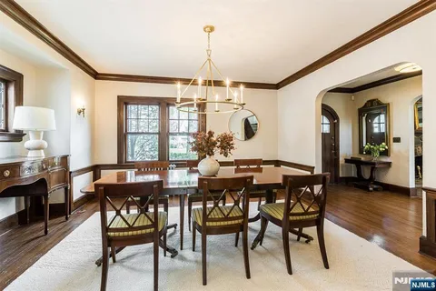 a view of a dining room and livingroom with furniture wooden floor a chandelier