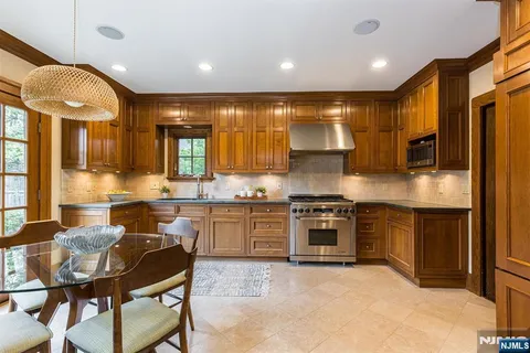 a kitchen with stainless steel appliances granite countertop a stove top oven a sink dishwasher and cabinets with wooden floor