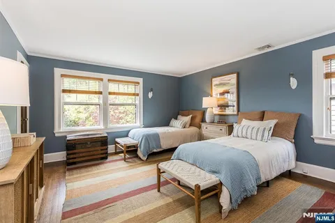 a bedroom with two beds and a large window