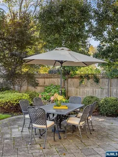 a view of a table and chairs in backyard under an umbrella