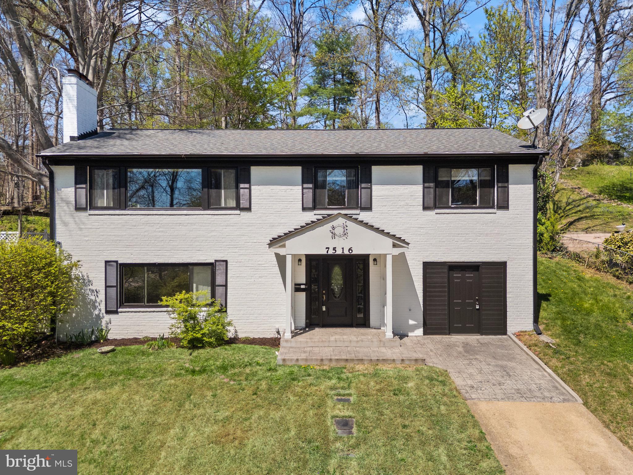 7516 Essex Avenue Springfield, VA 22150 - Photo 1 of 36 a front view of a house with a garden and trees