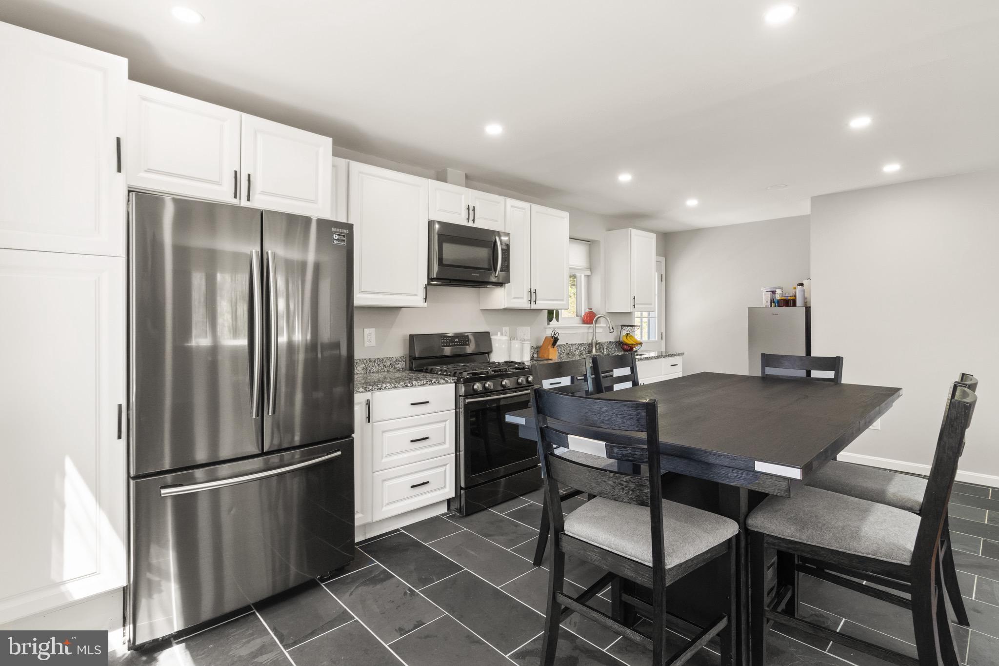 7516 Essex Avenue Springfield, VA 22150 - Photo 13 of 36 a kitchen with stainless steel appliances a refrigerator stove microwave and cabinets
