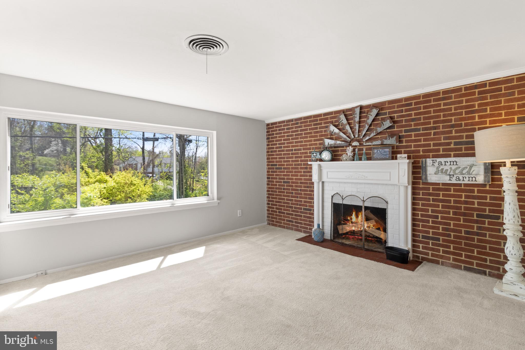 7516 Essex Avenue Springfield, VA 22150 - Photo 3 of 36 a view of an empty room with a fireplace and a window