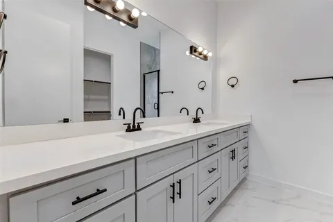 a bathroom with double sink and a mirror
