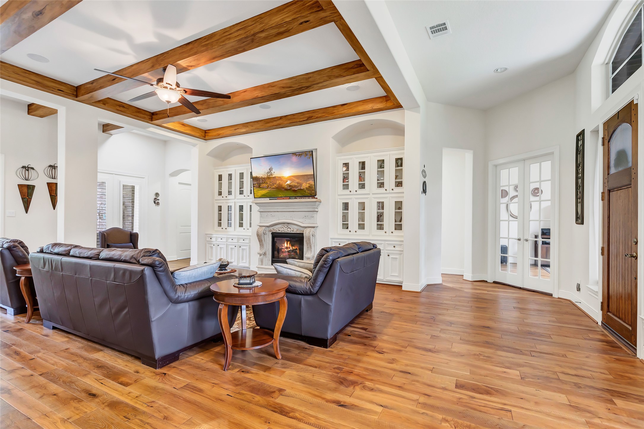 229 Sundog Road Huntsville, TX 77340 - Photo 7 of 50 Relax by the gas log fireplace in this spacious family room. Notice the high ceilings and wood beams. The French Doors on the right open to the Study