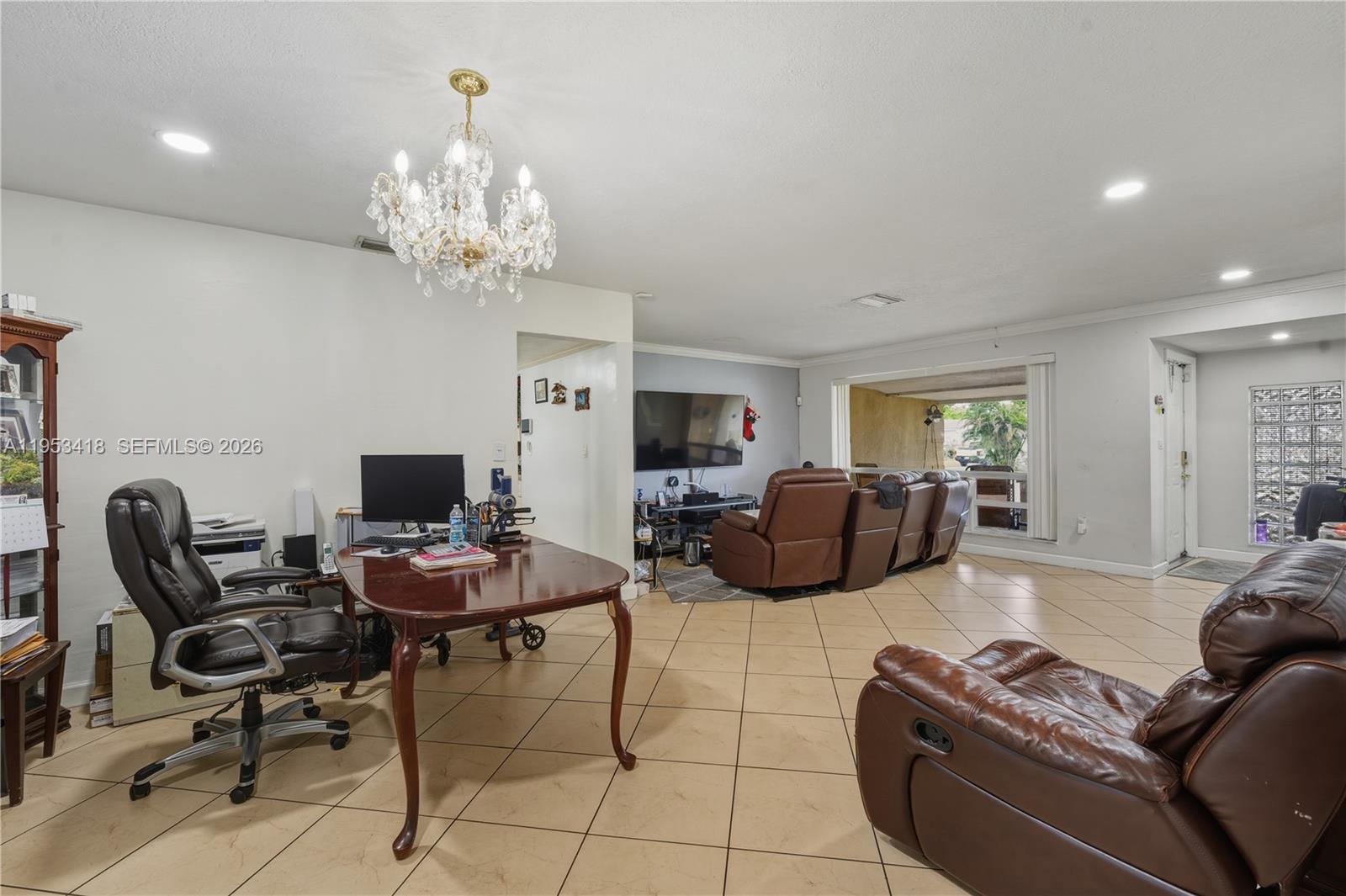 7630 Embassy Boulevard Miramar, FL 33023 - Photo 11 of 17 a living room with furniture a chandelier and a flat screen tv