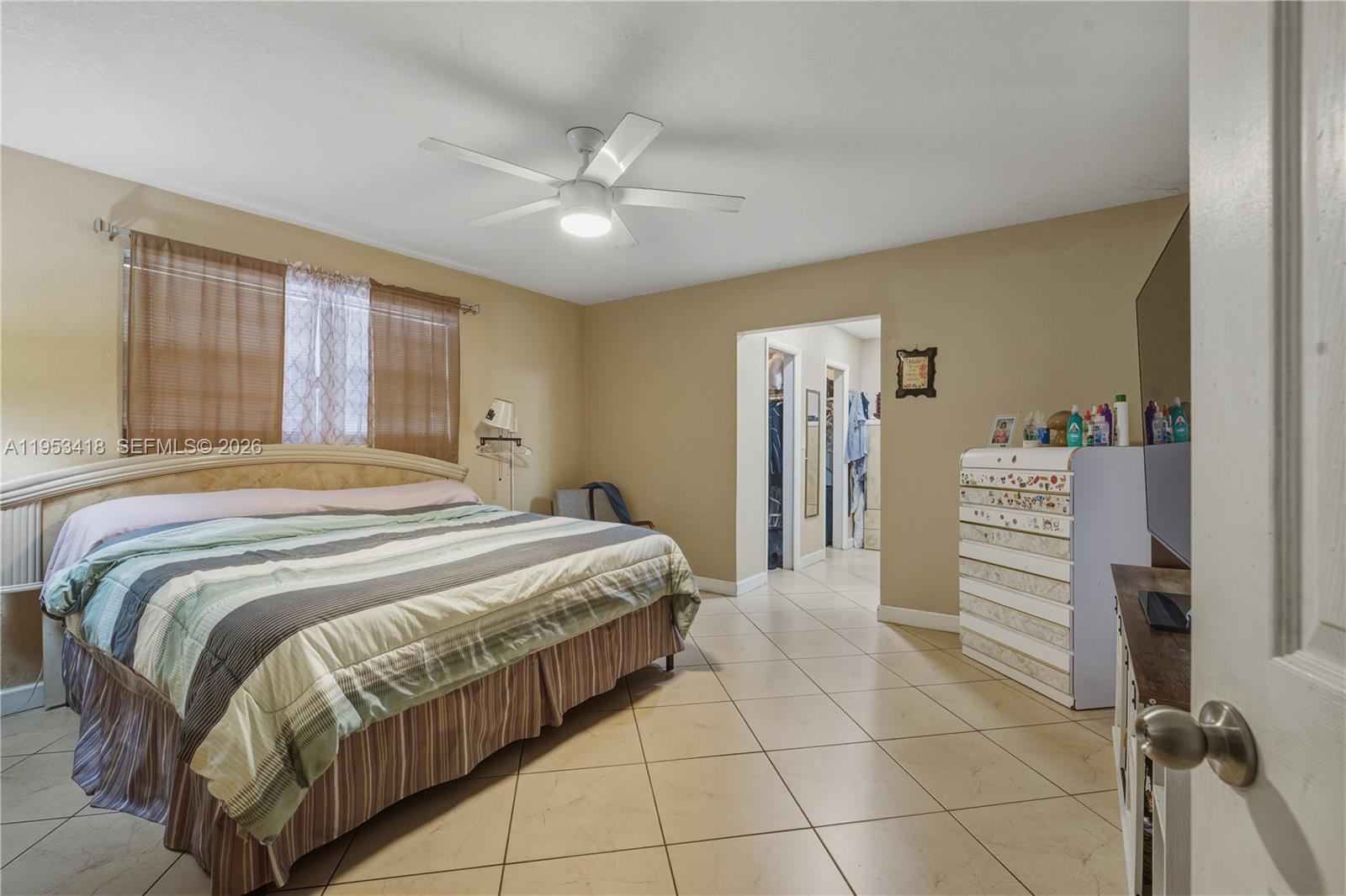 7630 Embassy Boulevard Miramar, FL 33023 - Photo 15 of 17 a bedroom with a bed and a chandelier
