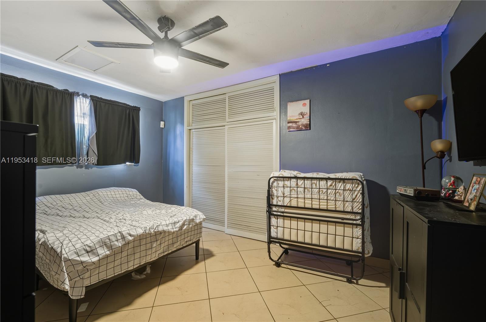 7630 Embassy Boulevard Miramar, FL 33023 - Photo 16 of 17 a bedroom with a bed and a chandelier