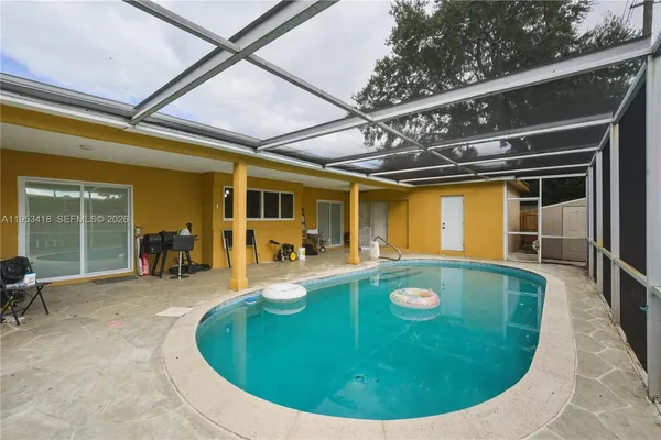a view of a swimming pool with a patio and a yard