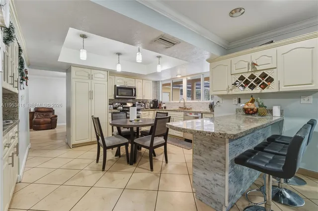 a kitchen with a dining table chairs and white appliances