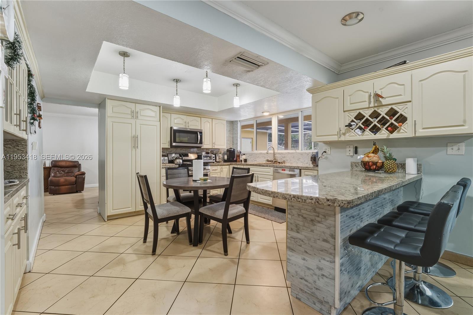 7630 Embassy Boulevard Miramar, FL 33023 - Photo 7 of 17 a kitchen with a dining table chairs and white appliances