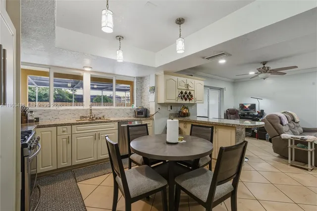 a kitchen with a dining table cabinets and chairs