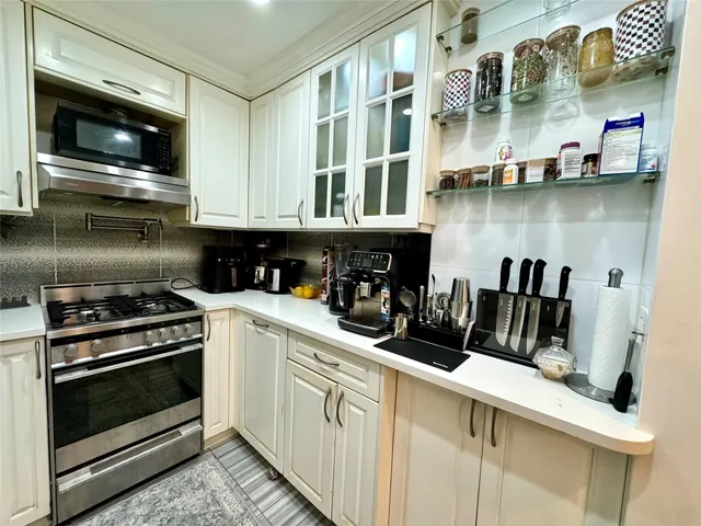a kitchen with stainless steel appliances granite countertop a stove and a microwave