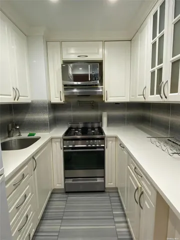 a kitchen with stainless steel appliances granite countertop a stove and a sink