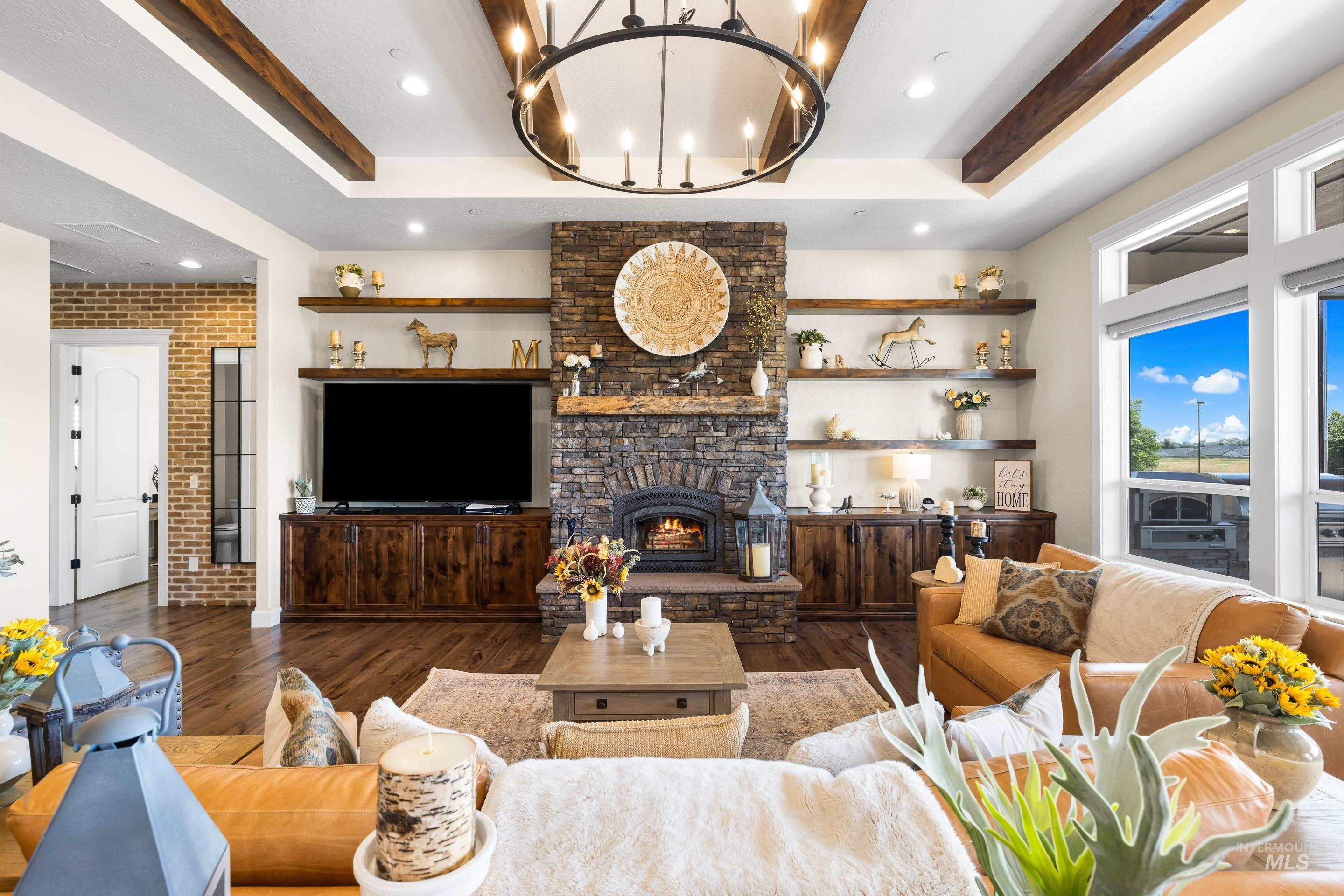 9819 Foothill Road Middleton, ID 83644 - Photo 17 of 49 Living area featuring a raised ceiling, wood finished floors, a stone fireplace, brick wall, and recessed lighting