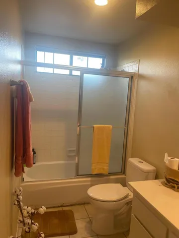 a bathroom with a granite countertop toilet and a shower