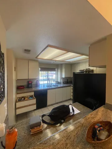 a kitchen with a refrigerator and a stove top oven
