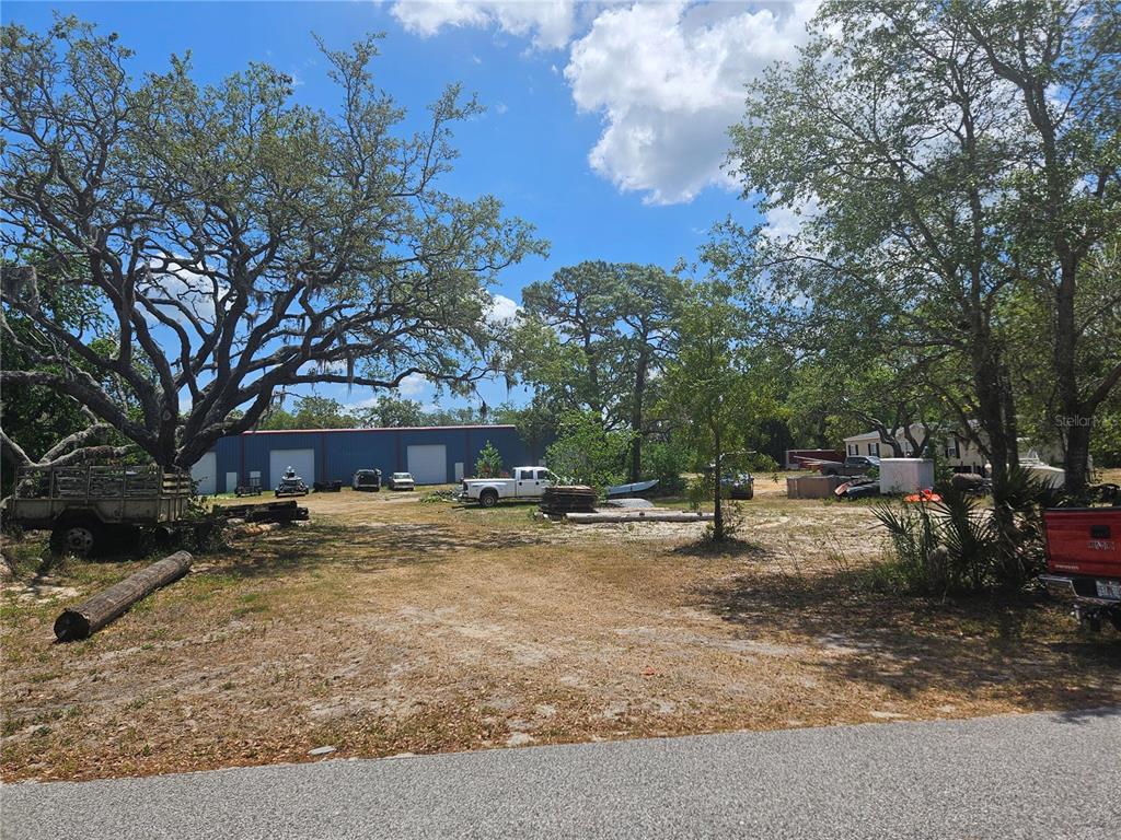 12414 Choctaw Trail Hudson, FL 34669 - Photo 2 of 3 a view of a house with a tree park and bench