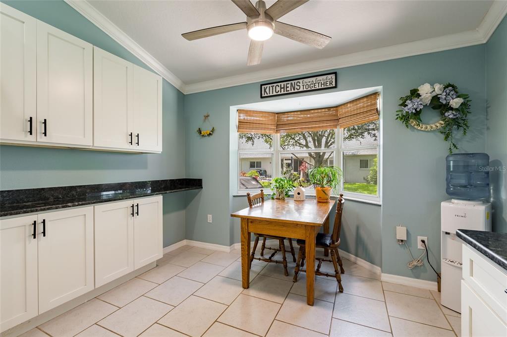 9238 Estrella Court New Port Richey, FL 34655 - Photo 16 of 37 a kitchen with granite countertop cabinets a dining table and chairs