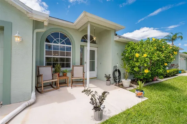 a view of a chair and table in backyard of the house