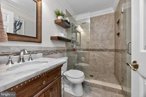 a bathroom with a granite countertop sink a toilet and a shower