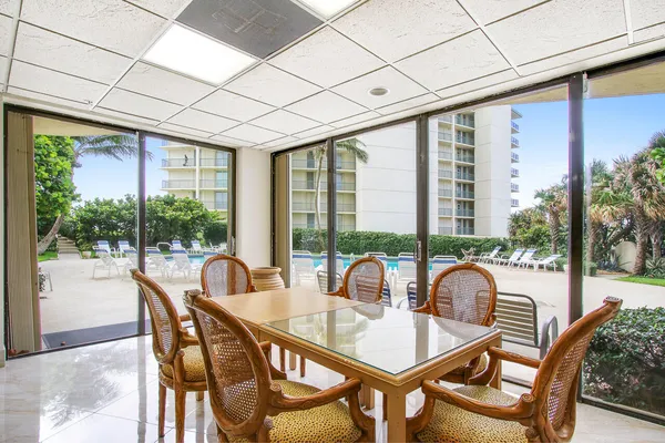 a dining room with furniture large windows and wooden floor