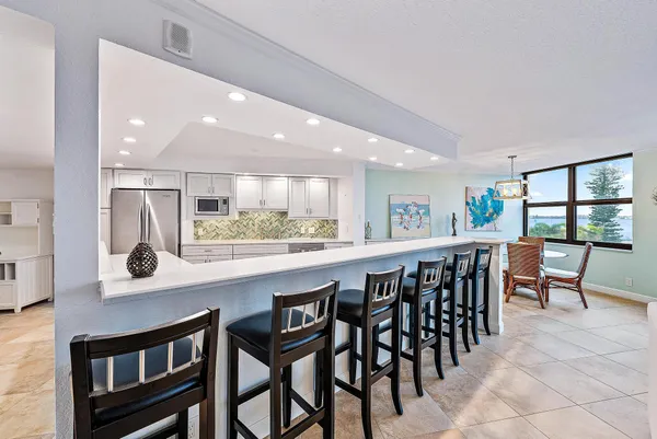 a kitchen with stainless steel appliances granite countertop table chairs sink and stove