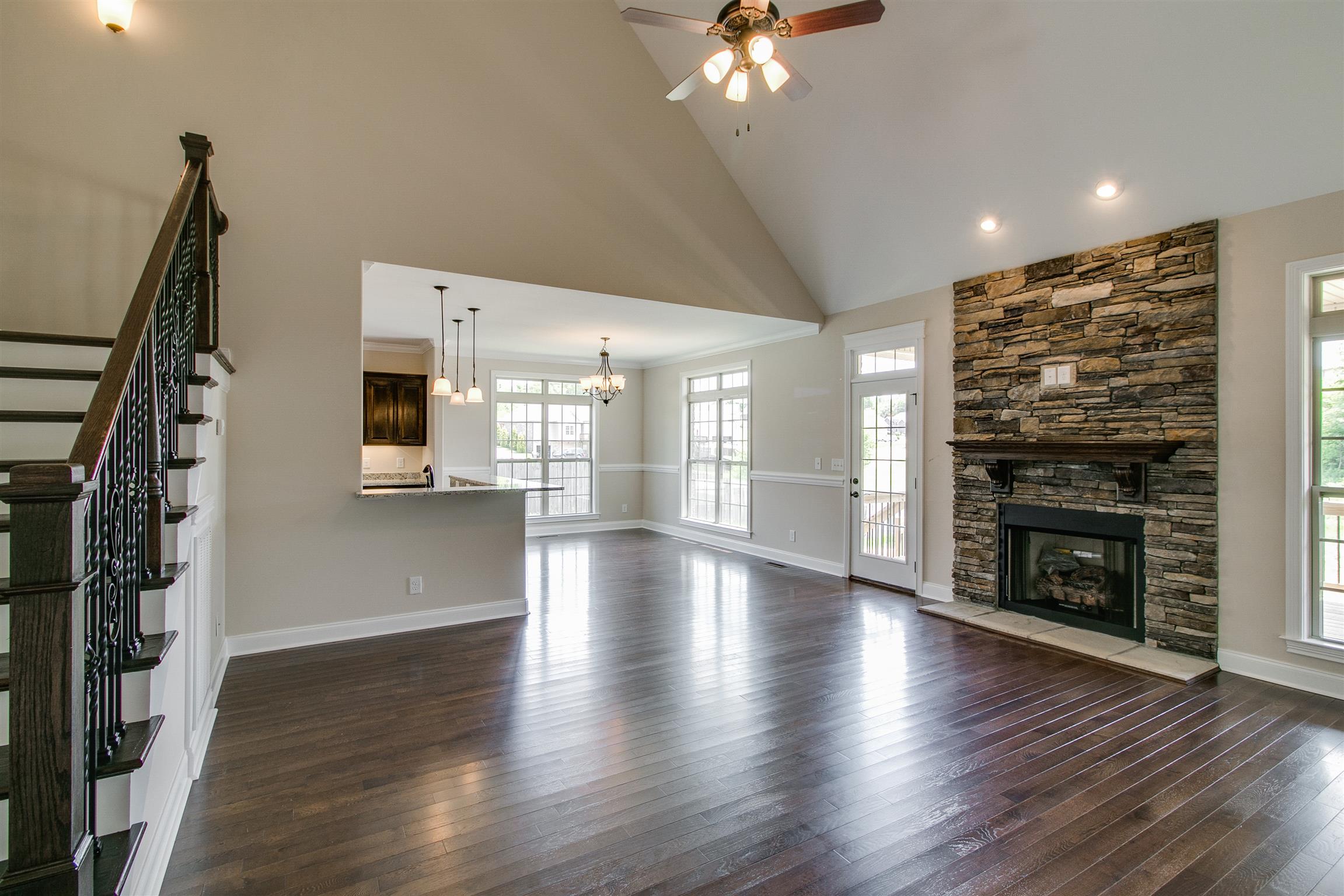 3548 Drake Road Adams, TN 37010 - Photo 6 of 30 a view of an empty room with wooden floor fire place and a kitchen