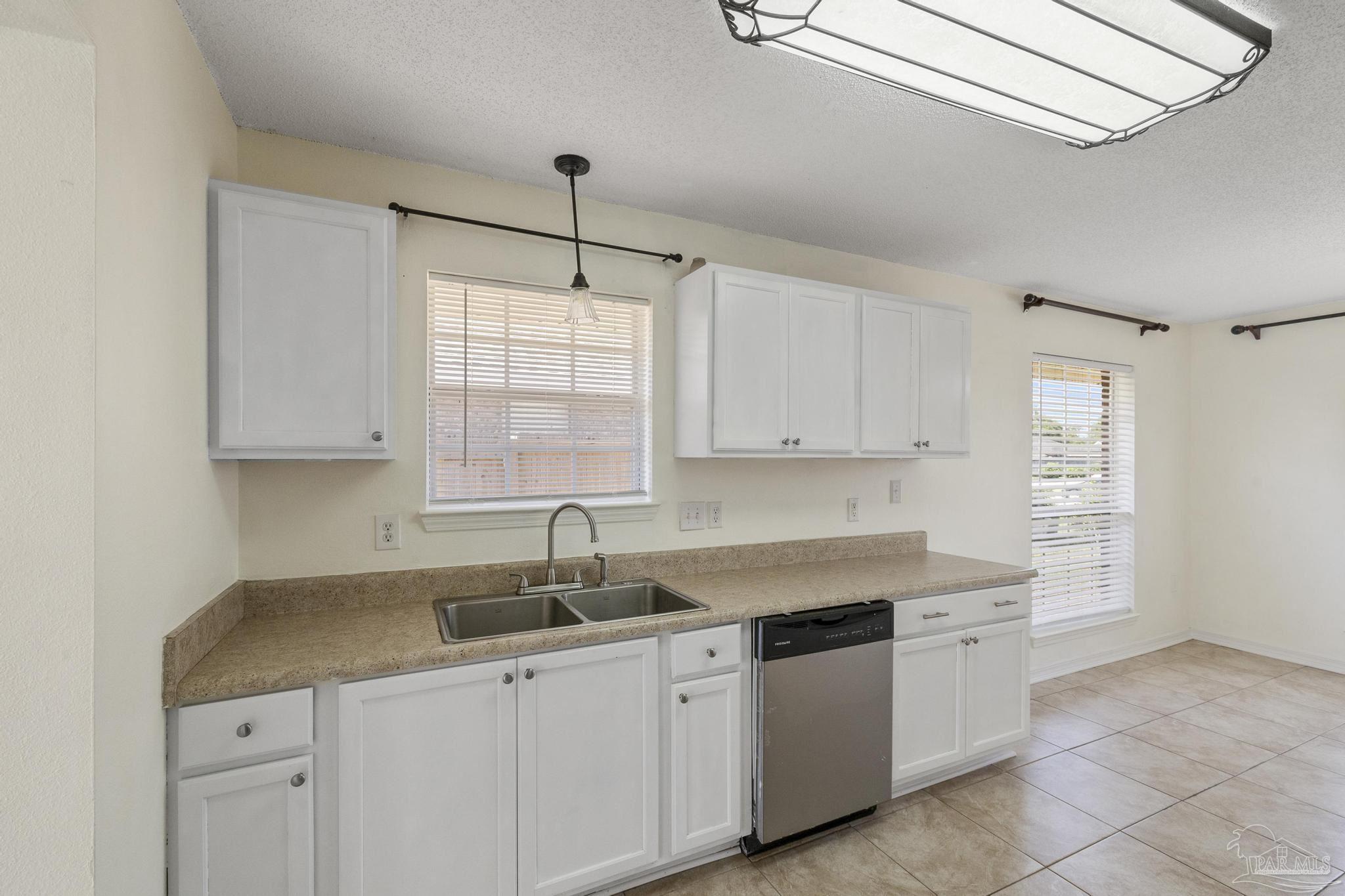 4769 Ribault Lane Milton, FL 32570 - Photo 13 of 34 a kitchen with white cabinets and window