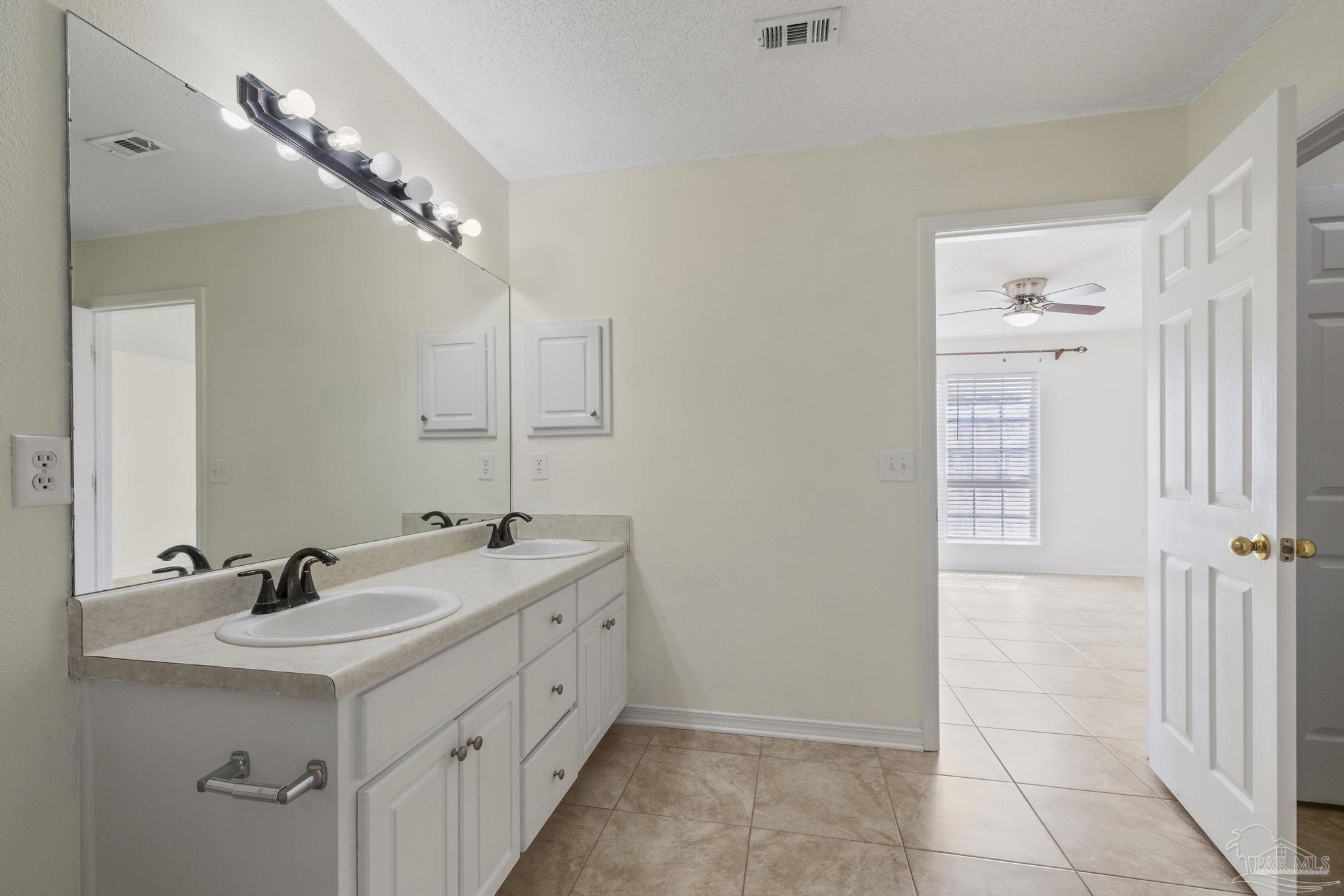 4769 Ribault Lane Milton, FL 32570 - Photo 21 of 34 a bathroom with a double vanity sink a mirror and a shower