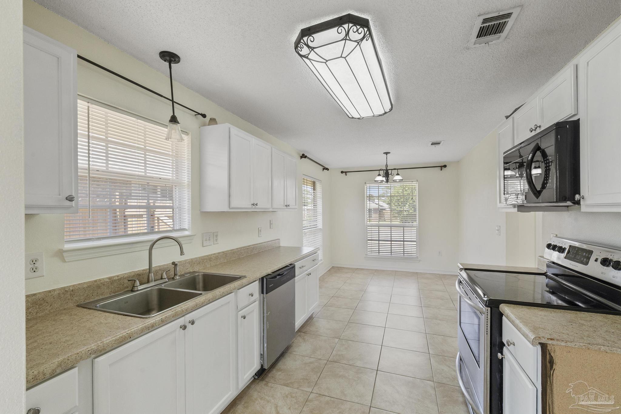 4769 Ribault Lane Milton, FL 32570 - Photo 4 of 34 a kitchen with stainless steel appliances a sink stove and cabinets