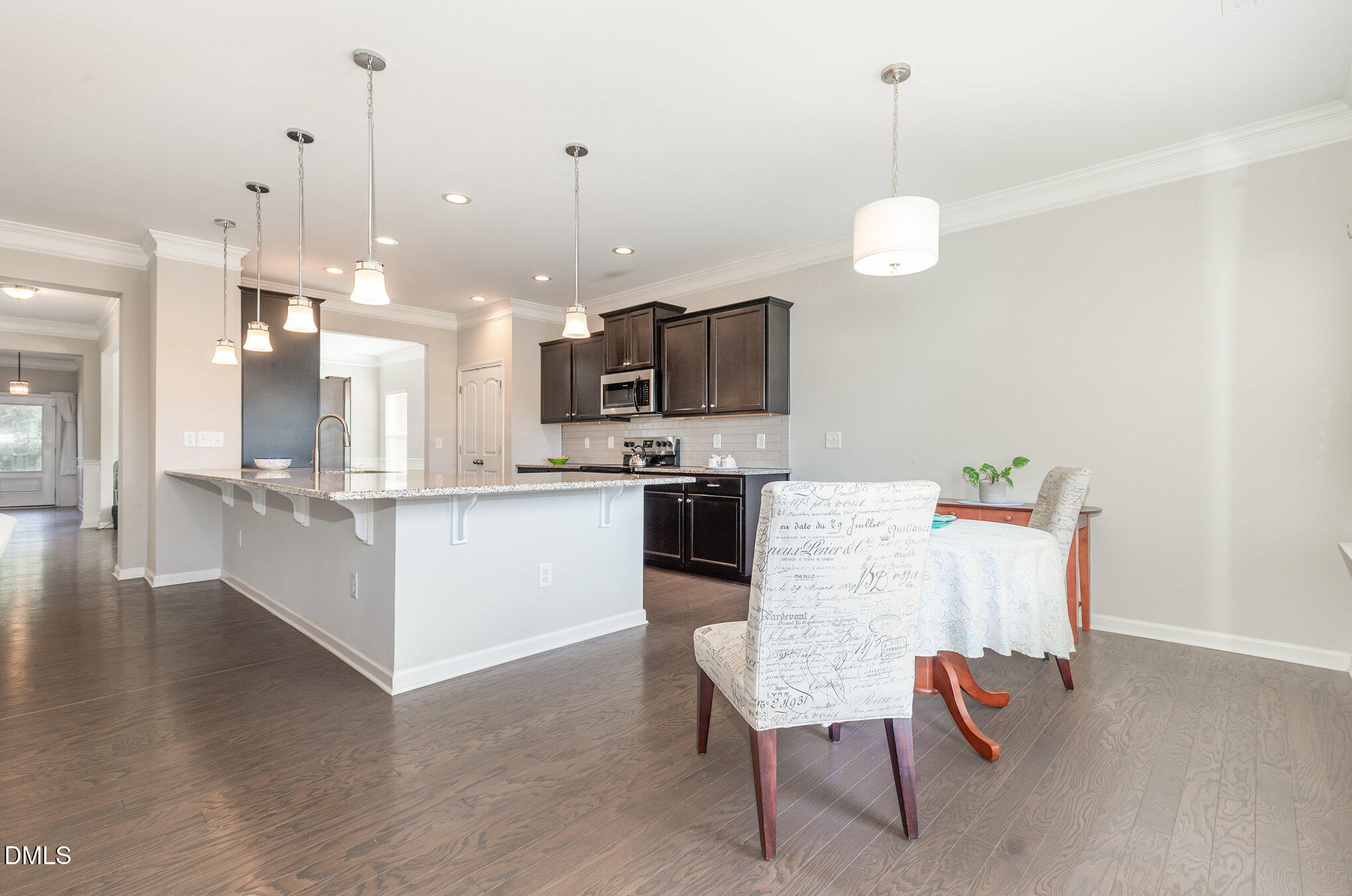 187 Highland Rhodes Drive Clayton, NC 27520 - Photo 7 of 23 a large white kitchen with a center island and stainless steel appliances