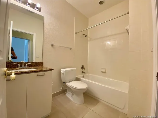 a bathroom with a granite countertop toilet a sink and a bathtub