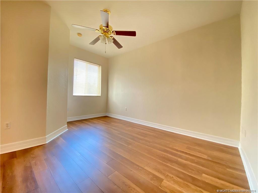 59 Southeast Palermo, Unit 102 Stuart, FL 34994 - Photo 12 of 18 an empty room with wooden floor fan and windows