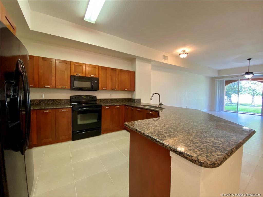 59 Southeast Palermo, Unit 102 Stuart, FL 34994 - Photo 3 of 18 a kitchen with stainless steel appliances granite countertop a sink dishwasher and refrigerator