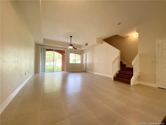 a view of a livingroom with wooden floor and a ceiling fan