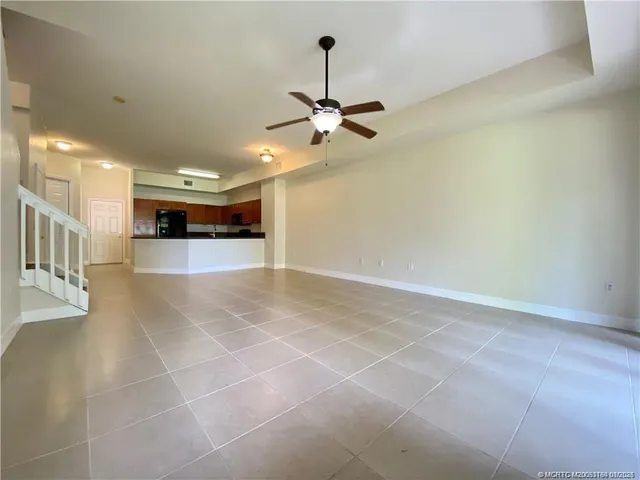 a view of a livingroom with a kitchen and a ceiling fan