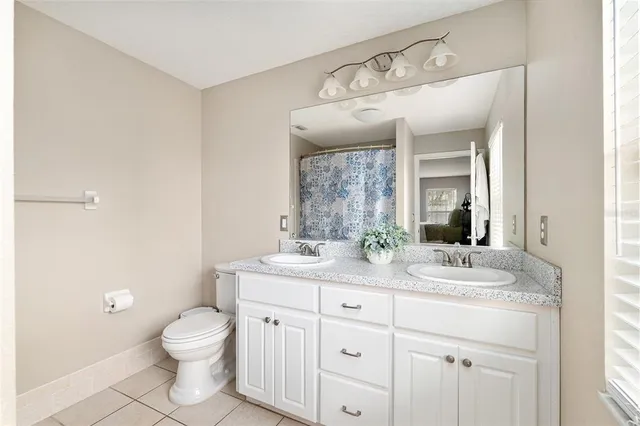 a bathroom with a granite countertop sink mirror and toilet
