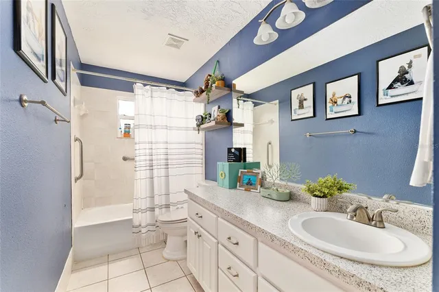 a bathroom with a granite countertop sink mirror vanity and toilet