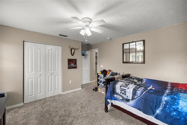 a bed room with a bed and a ceiling fan