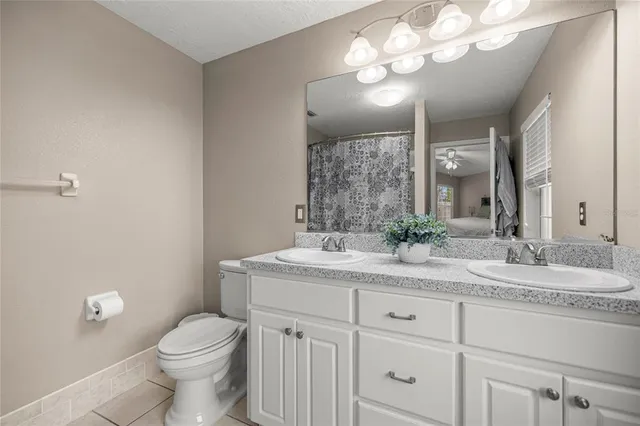 a bathroom with a granite countertop sink mirror and toilet