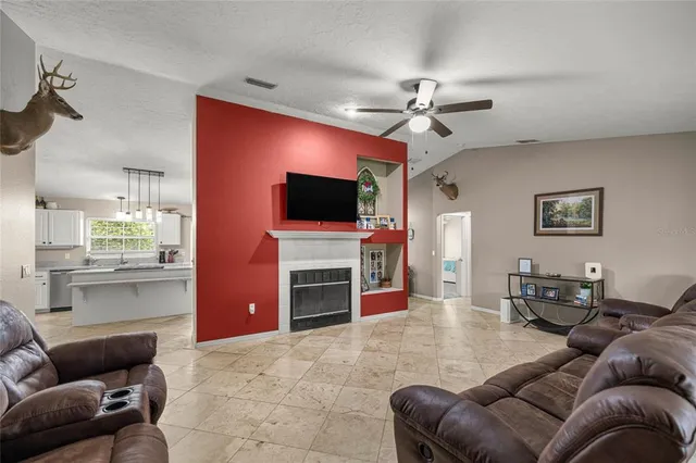 a living room with furniture a flat screen tv and kitchen view