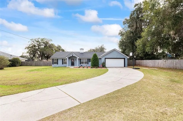 a view of house with pool and yard