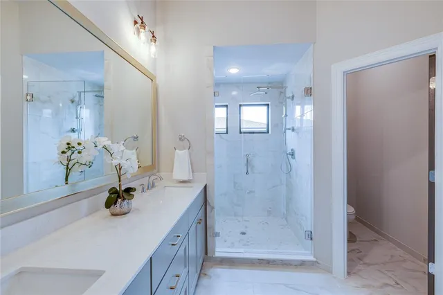 a bathroom with a shower sink and mirror